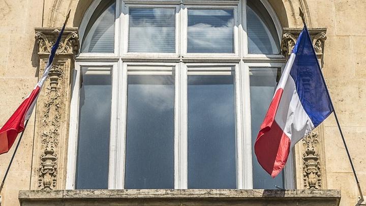 French flags on either side of an arched window. 